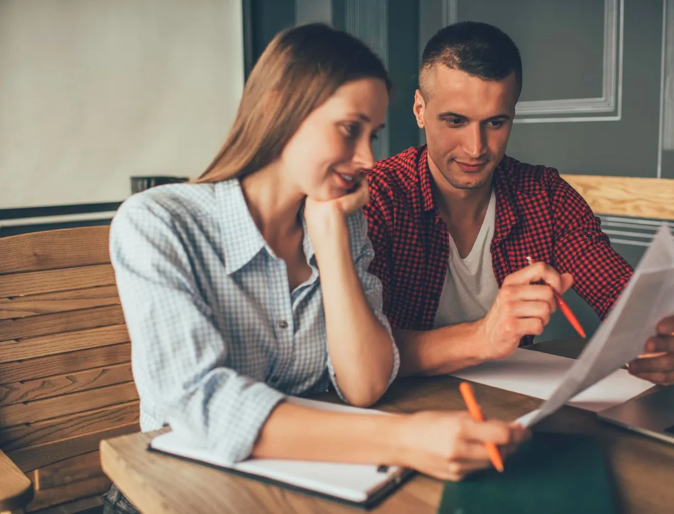 Couple reviewing paperwork together at a table.