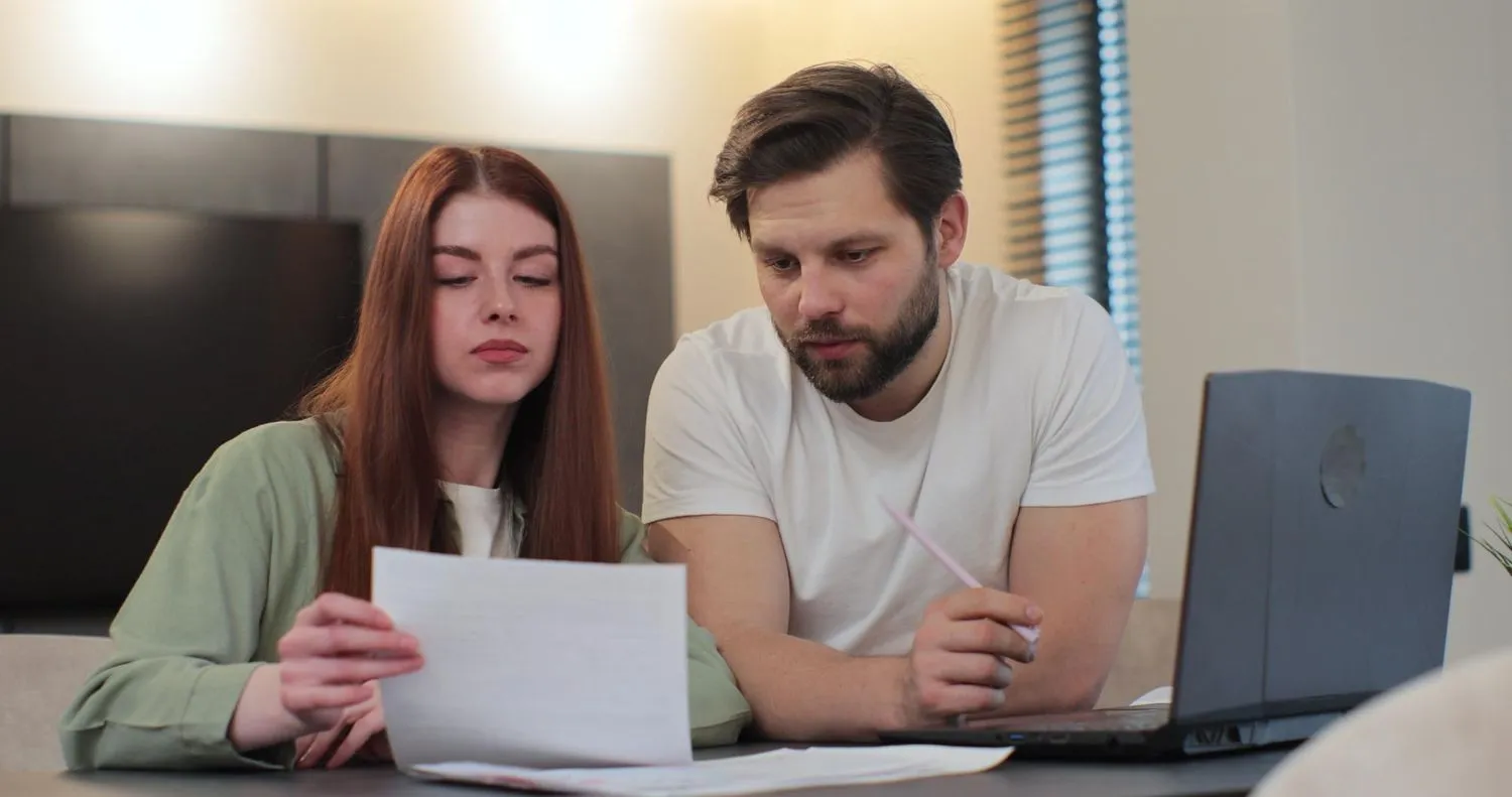 Financial advisor explaining documents to a couple at a table.